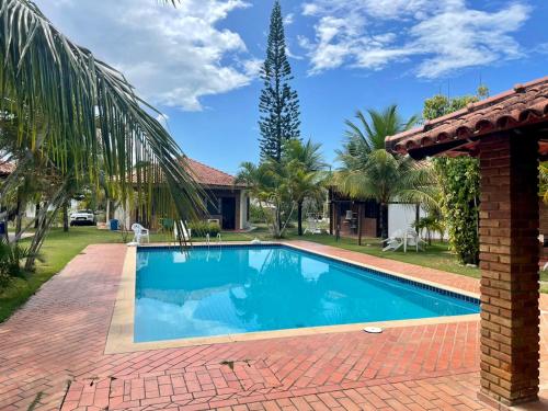 普拉杜Bangalô Amarelo的一座带房子的庭院内的游泳池