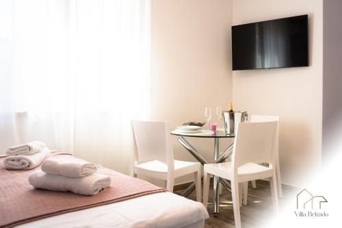 贝尔格莱德Belrado Apartments的客房设有桌子、床和桌椅。