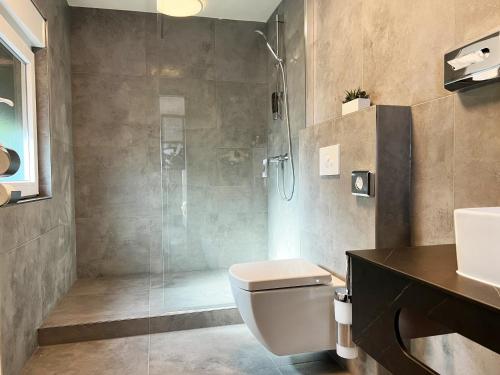 新基兴Hotel Da Toni的带淋浴、卫生间和盥洗盆的浴室