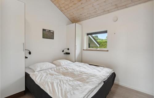 阿里尔Cozy Home In Toftlund With Kitchen的卧室配有带白色墙壁和窗户的床