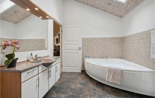 阿里尔Cozy Home In Toftlund With Kitchen的浴室配有大型白色浴缸和水槽