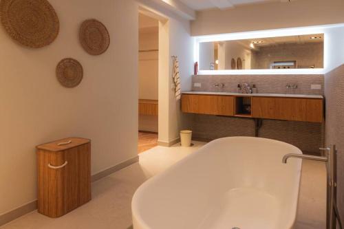 阿姆斯特丹Newly renovated luxurious 200 SQM loft in city centre的一间带浴缸和大镜子的浴室