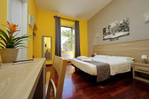 罗马LHG Comfy Rooms的配有一张床和一张书桌的酒店客房