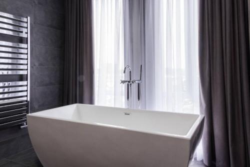 基希讷乌城市公园酒店的窗户前带白色浴缸的浴室