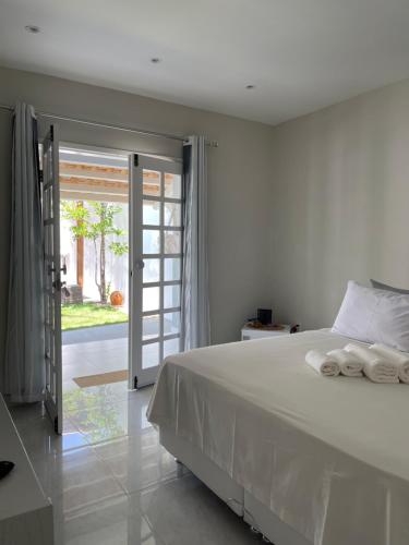 卡诺格布拉达Charlotte House的卧室配有白色的床和滑动玻璃门