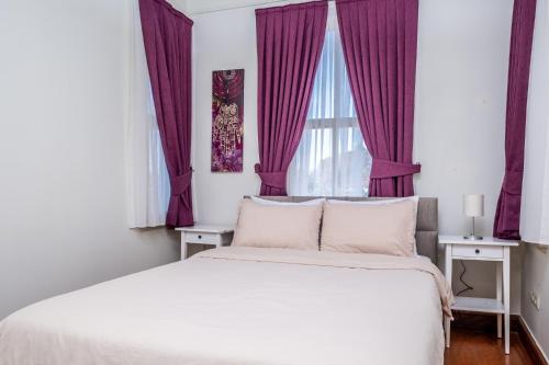伊斯坦布尔Pavilion with Bosphorus View in Anadolu Hisari的一间卧室配有一张大床和紫色窗帘
