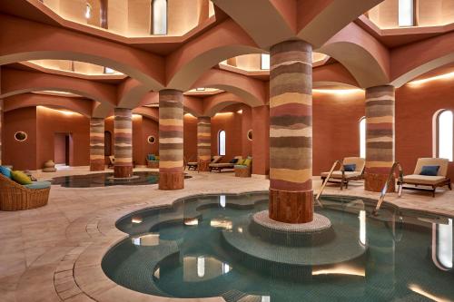 赫尔格达艾高娜施泰根博阁高尔夫度假酒店的酒店大堂设有游泳池和柱子