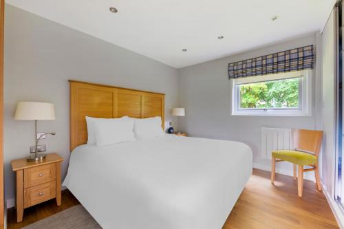 康福斯松湖钻石度假酒店的卧室配有一张白色大床和一把椅子