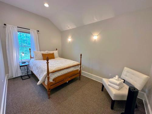 杰斐逊68CP Luxury farmhouse at the award-winning Bellevue Barn, 2 min to Santa's Village, AC, fireplace的一间卧室配有一张床、一张桌子和一个窗户。