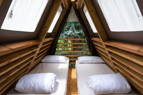 拉科纳Casa Dei Prati Camping Village的带2扇窗户的客房内的2张床