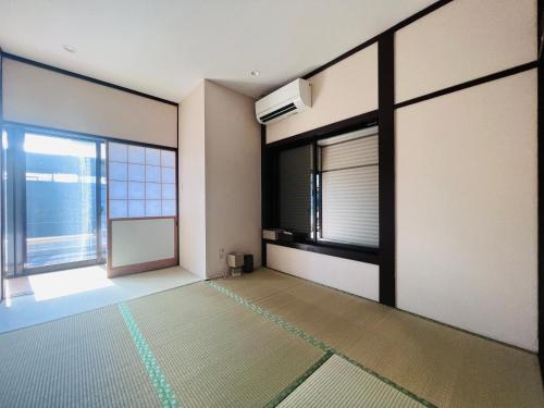 千叶Jun Resort的一间空房间,设有大窗户,一间房间