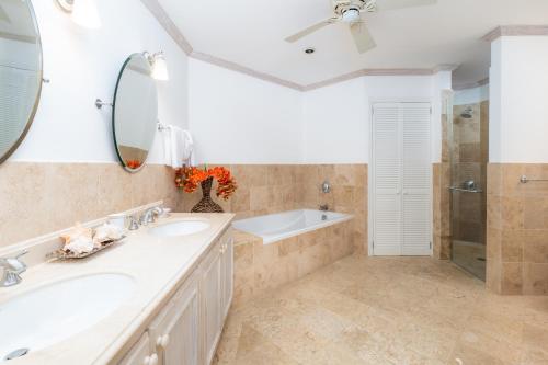 圣詹姆斯Royal Westmoreland - Royal Apartment 214 by Island Villas的浴室设有2个水槽、浴缸和镜子