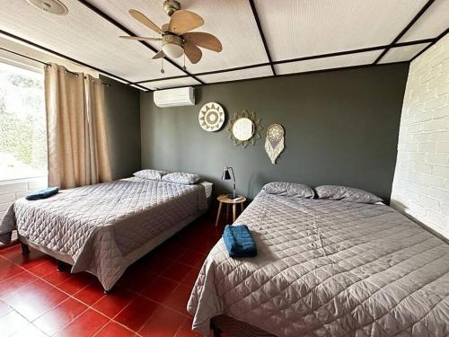 圣萨尔瓦多Outstanding House in San Benito!的一间卧室配有两张床和吊扇