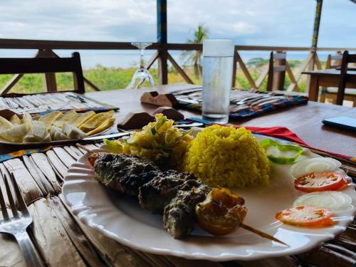 M. PeixeMonte Mar SãoTomé的餐桌上放着一盘饭和蔬菜的食物