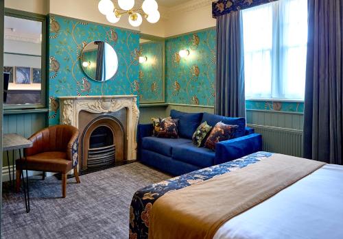 阿尔德利埃奇阿尔德利埃奇酒店的一间卧室配有一张床、一张沙发和一面镜子