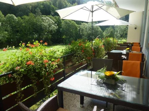 道恩Landhotel Lodge by Landhotel Krolik的天井配有桌子、雨伞和鲜花