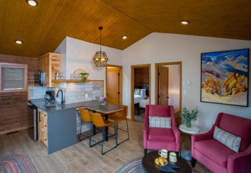 贾斯珀贝尔山小屋酒店的厨房以及带粉红色椅子和桌子的客厅