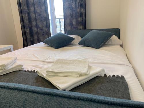 巴尔Stylish studio with private garage的一张带两个枕头的床和毛巾
