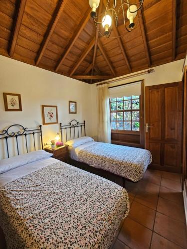 下布雷尼亚Corral de Payo El Lagar的一间卧室设有两张床和窗户。