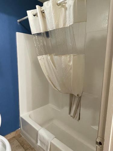 章克申城Express extended的浴室内设有带浴帘的白色浴缸