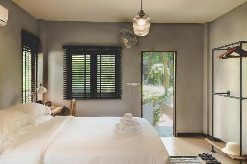 拜县Re Connect Pai - Keys Resort的卧室设有一张白色大床和一扇窗户。