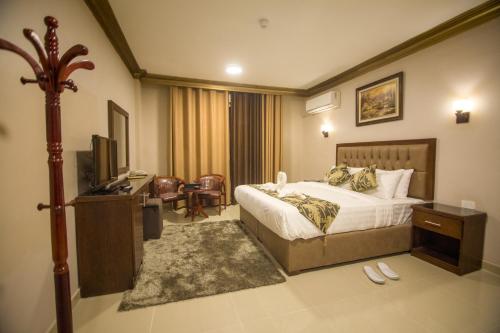安曼Grape Village Hotel的酒店客房,配有床和电视