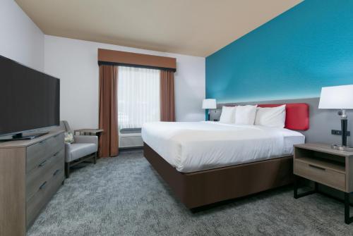 阿林顿Comfort Suites Arlington - Entertainment District的一间酒店客房,配有一张大床和一台平面电视