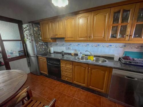 下布雷尼亚Lourdes 1 casa compartida solo con la anfitriona的厨房配有木制橱柜、水槽和桌子
