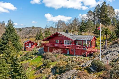 灵达尔Gemütliches helles Ferienhaus am See mit Panoramaseeblick + Hütte und nahe Meer的山边的红色房子