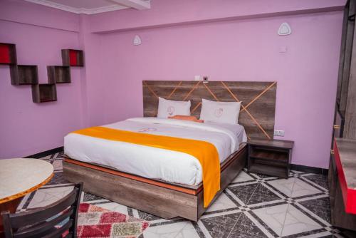 纳库鲁Hotel Good Putt的一间卧室配有一张带橙色毯子的大床