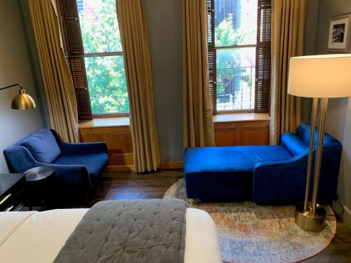 纽约The Historic Blue Moon Hotel - NYC的客厅配有蓝色的家具和窗户。