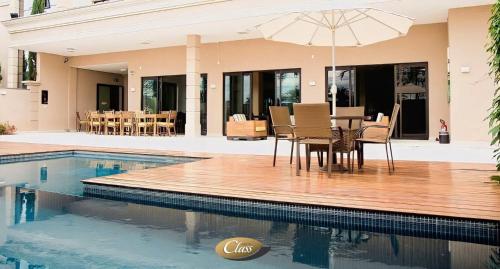 阿尔费纳斯阿尔费纳斯卡拉斯酒店的游泳池旁带遮阳伞的餐桌