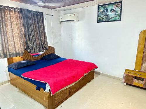达曼Chirag Banglow 2BHK的一间卧室配有一张带红色毯子的床