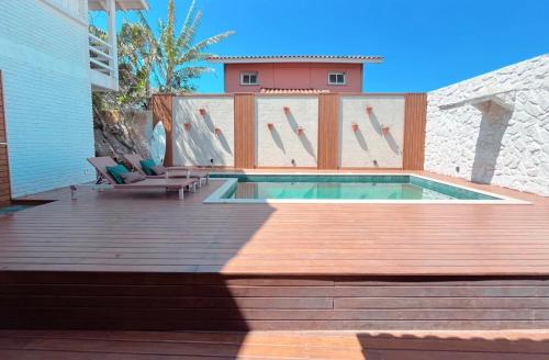 Casa com piscina climatizada em frente à Praia do Santinho内部或周边的泳池