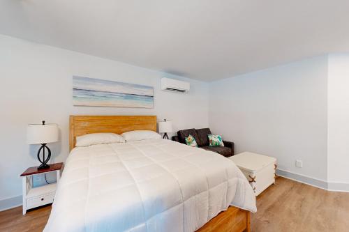 柏斯海滩Town of Rehoboth Beach - 99 Sussex St Unit #6的白色卧室配有一张大床和椅子
