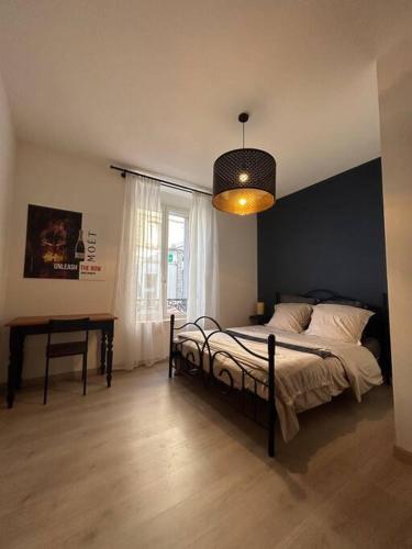 埃佩尔奈La Chambre St Vincent的一间卧室配有一张床、一张桌子和一个窗户。