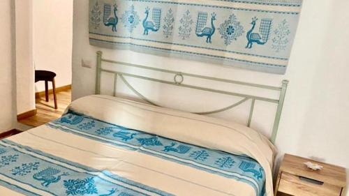 AustisAZIENDA AGRITURISTICA S'ARGALASI - B&B - AFFITTACAMERE Loc S'Argalasi Austis的一张位于蓝色和白色墙壁的床铺