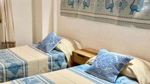 AustisAZIENDA AGRITURISTICA S'ARGALASI - B&B - AFFITTACAMERE Loc S'Argalasi Austis的客房配有两张带蓝白色枕头的床。