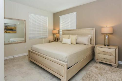 基西米Awesome Apartment at Storey Lake SL47318的一间卧室配有一张带2个床头柜和镜子的床