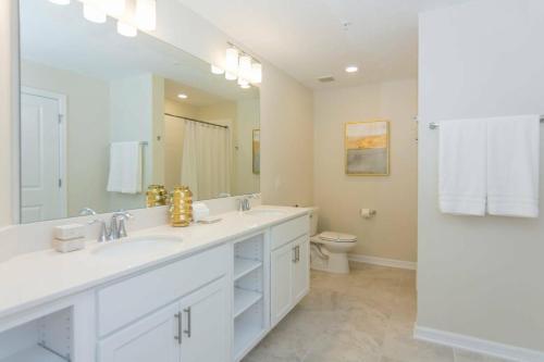 基西米Awesome Apartment at Storey Lake SL47318的白色的浴室设有2个盥洗盆和1个卫生间。