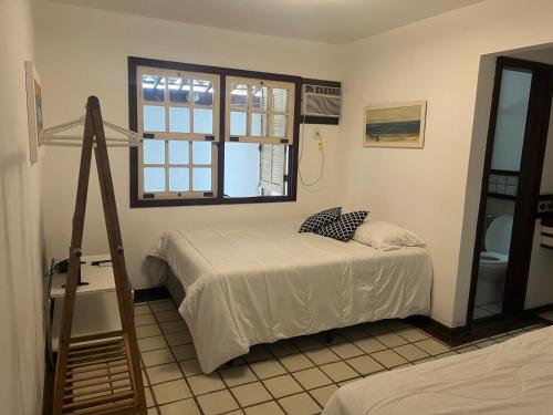 布希奥斯Casa em geribá的一间卧室设有一张床、一个窗口和梯子