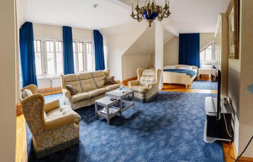 斯米尔泰内Park Hotel Brūzis的客厅配有沙发、椅子和1张床