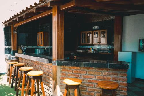 曼塔HOTEL MANTA BEACH MADRIGAL的酒吧前的一排木凳