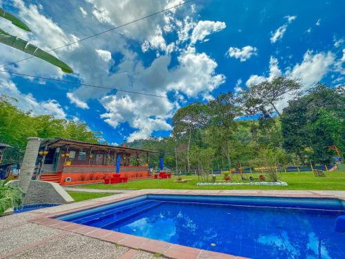 萨兰托CABAÑAS Finca Hotel Villa Natalia -Salento Quindio的一个带游乐场的庭院内的游泳池
