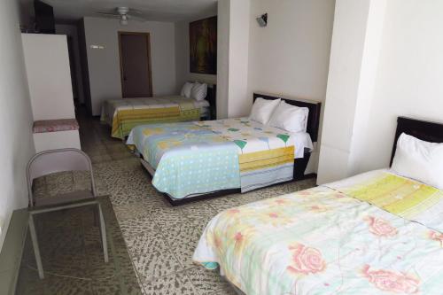阿瓜斯卡连特斯HOTEL LLANITO AGS的酒店客房,设有三张床和椅子