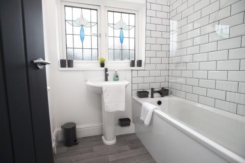 雷德卡Sandringham House的白色的浴室设有浴缸和水槽。