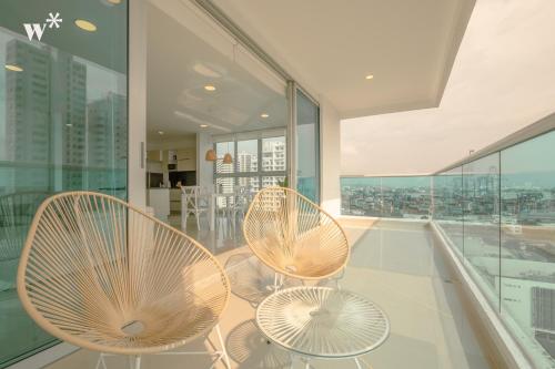 卡塔赫纳Wynwood Las Flores in Cartagena的阳台设有两把椅子和桌子,阳台设有窗户