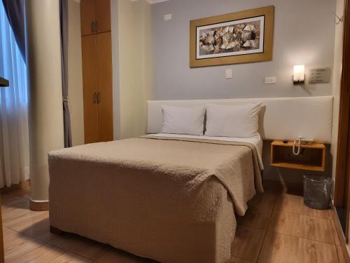 瓦乔Hotel Punta Rocas - Huacho的卧室配有带白色枕头的大床