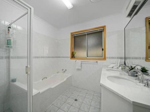 LavingtonViews on Quicks Hill的浴室配有2个盥洗盆、浴缸和淋浴。