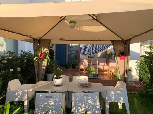 艾西拉Appartement de vacances BERALMAR CHEZ HOUDA的帐篷下配有桌椅的天井